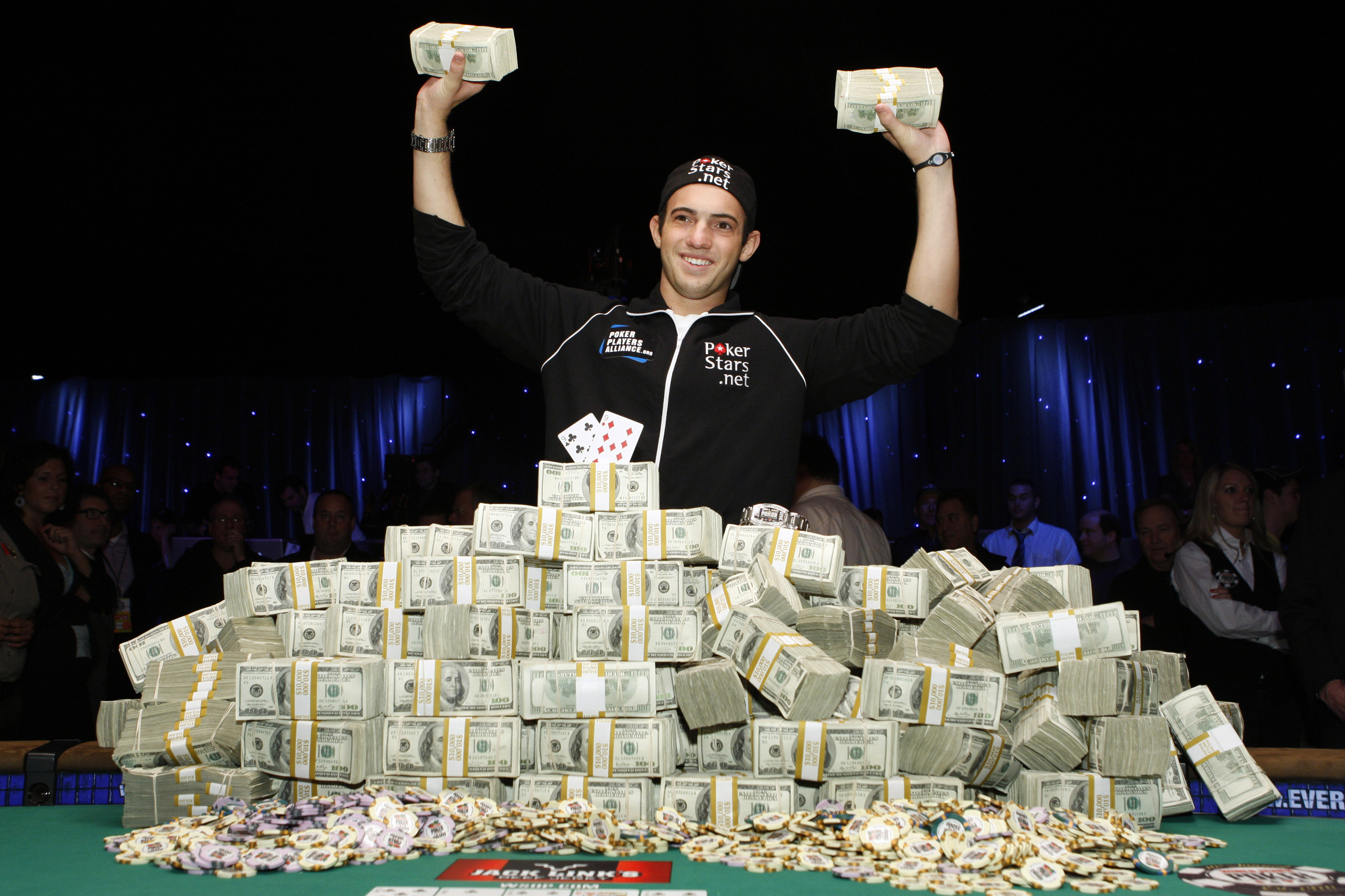 Joe Cada, a 21-year old poker professional from Michigan, poses with bundles of cash after winning $8.5 million in prize money at the World Series of Poker tournament in Las Vegas